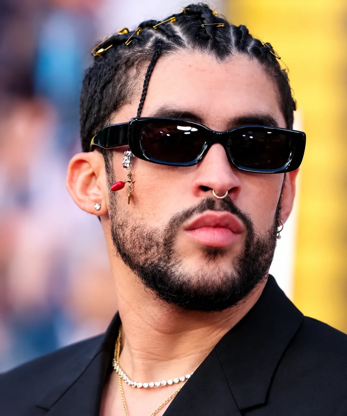 Retrato de Bad Bunny con gafas oscuras y trenzas